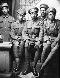 Black and white photograph of five soldiers from the No. 2 Black Battalion in uniform sitting together.