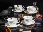 Tea cups and saucers on old books with a crow vintage bottle.
