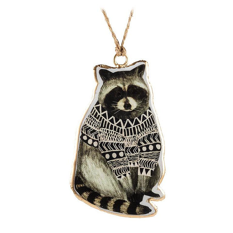 Pendant with raccoon design wearing a patterned sweater on a white background