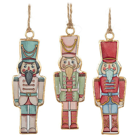 Three colorful nutcracker ornaments hanging against a white background