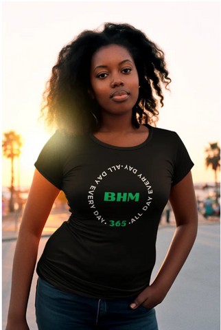 Woman wearing a black t-shirt with BHM in green in middle with writing around it.