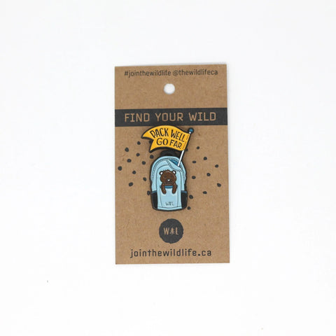 Enamel pin of a bear in a backpack. Says "Pack Well, Go Far."