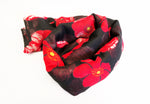 Scarf tied to show red poppies on sheer black background.