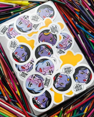 Stickers on a laptop on a pile of colorful pencils