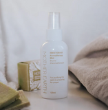 White bottle of 'Sweetgrass Aromatherapy Mist' by Mother Earth on a neutral background