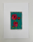 Felted artwork of red poppies on a turquoise blue.