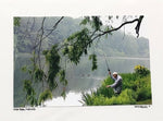 Photo Card of a Fisher fishing by a pond, three ducks in background. 