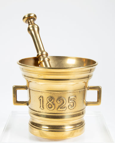 Brass mortar marked 1825 with two handles, one on each side and a pestle inside