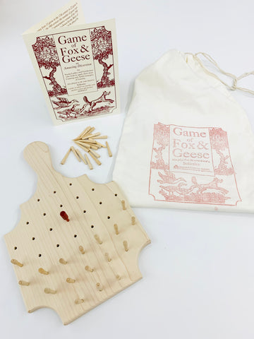 Game of Fox and Geese game board with pegs set up and carrying cotton bag