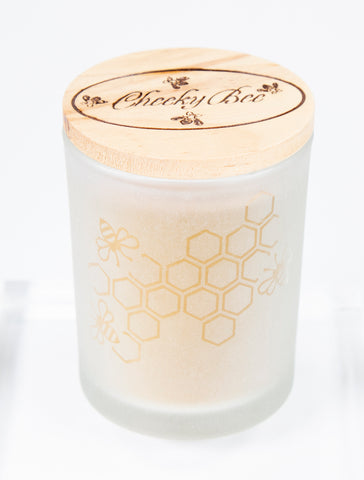 Frosted glass candle holder with honeycomb design and wooden lid featuring "Cheeky Bee" logo. 