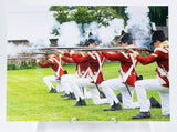 Postcard of soldiers in redcoats, firing muskets and kneeling
