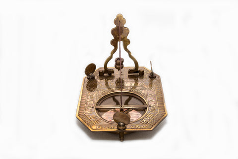 Close product shot of brass pendulum sundial and compass