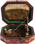 Brass pendulum sundial and compass in open wooden box.