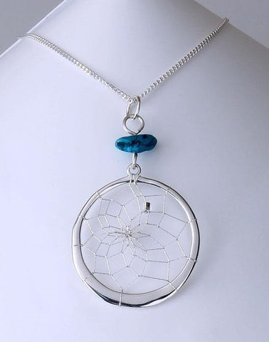Close product shot of sterling silver dream catcher pendant with turquoise stone