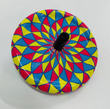Tin spinning top with kaleidoscope design in blue pink and yellow