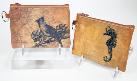 Two coin purses featuring black and white illustrations on a tan coloured background.  