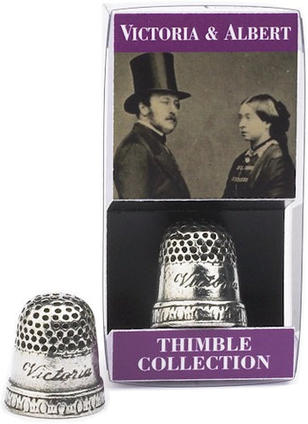 Pewter thimble engraved with "Victoria" beside thimble in packaging