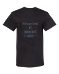 Haunted by Mackenzie House printed in white lettering on a black t-shirt