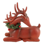 Sitting red deer figurine with a wreath around it's neck.