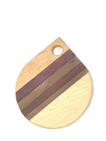 A Board in the shape of tear drop with a circular hole at the top. Stripes of different wood in the centre. 