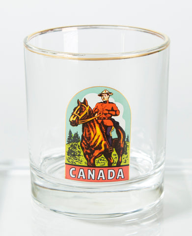 Gold rimmed bar glass with a vintage picture of a Mountie on a horse with Canada underneath