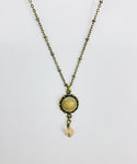 Necklace featuring vintage white button with butterfly design and crystal drop