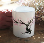 Hand holding Kikkerland blossom morph mug, with colours in transition
