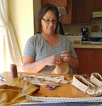 Image of Susan Hill making a pair of moccasins