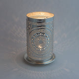 Image of tin lamp with a lit candle inside
